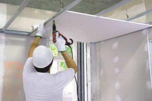 operaio che fissa una parete di cartongesso